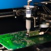 Dispensing solder paste onto a circuit board, a prime example of rheology’s role in electronics manufacturing.