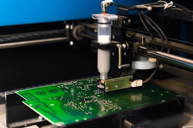 Dispensing solder paste onto a circuit board, a prime example of rheology’s role in electronics manufacturing.